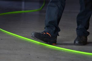 Uomo cammina su tubo al neon verde